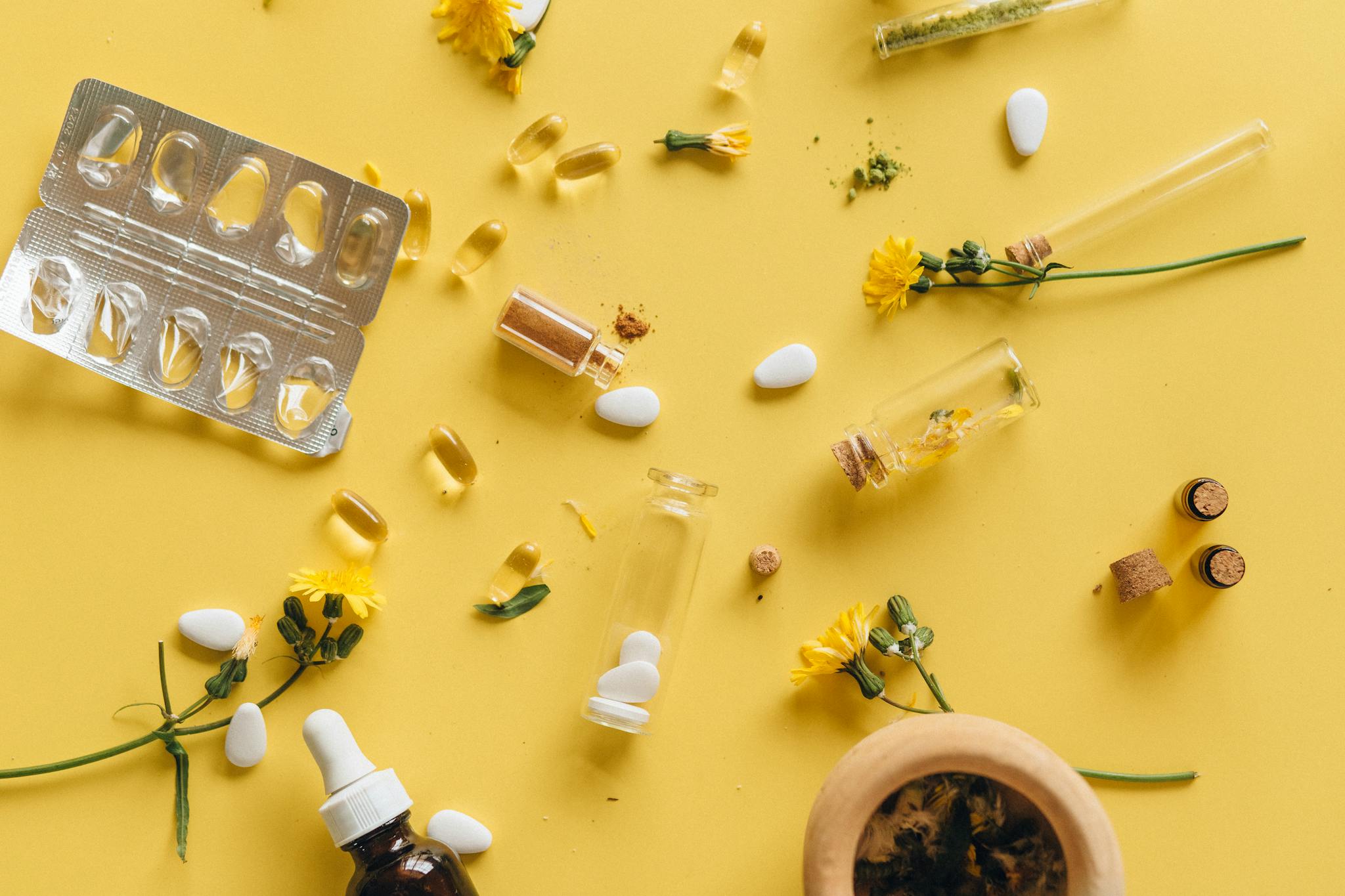 Herbal supplements and medicine capsules on a vibrant yellow background for health themes.